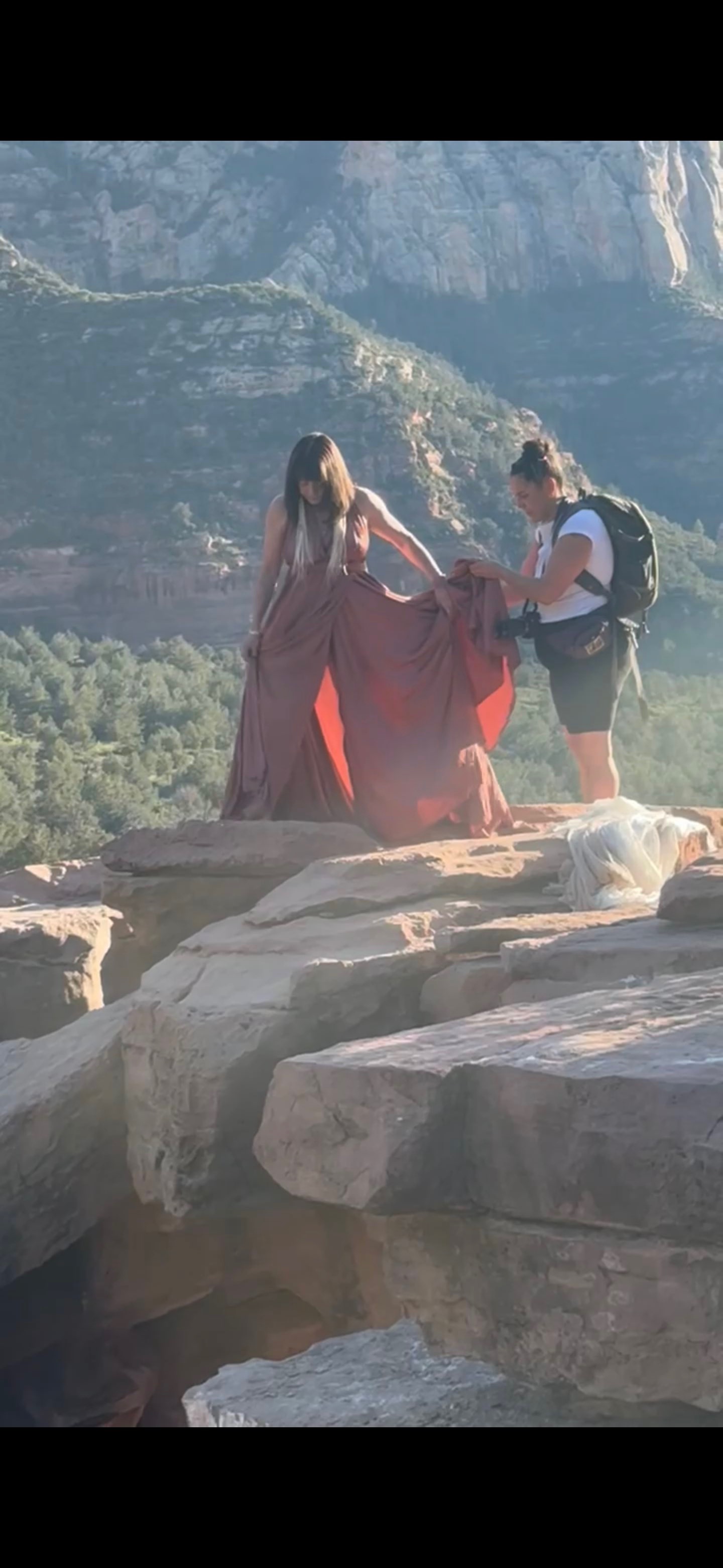 Terii being supported by a friend on the rocks, preparing for the photo